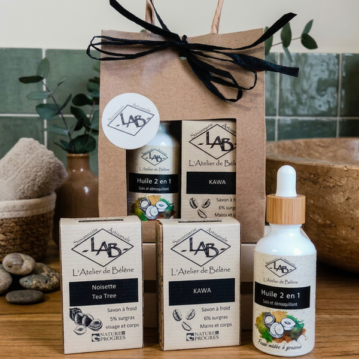 Routine minimaliste visage composée d'une huile 2 en 1 peaux mixtes à grasses + un savon noisette/Tea-tree + un gommage café emballé dans sachet kraft à fenêtre. savons artisanaux BIO dans salle de bain